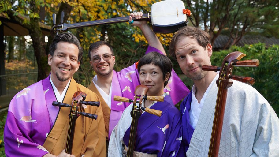 Kyle Abbott and fellow musicians in kimono holding shamisen